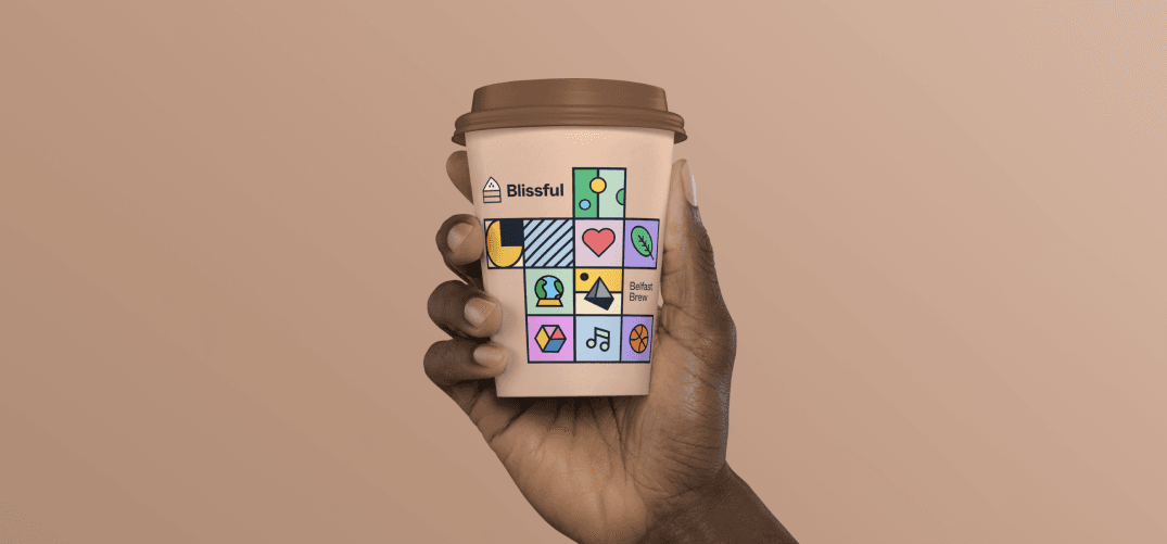 A hand holding a peach takeaway cup, the tiles framing the label Belfast Brew.