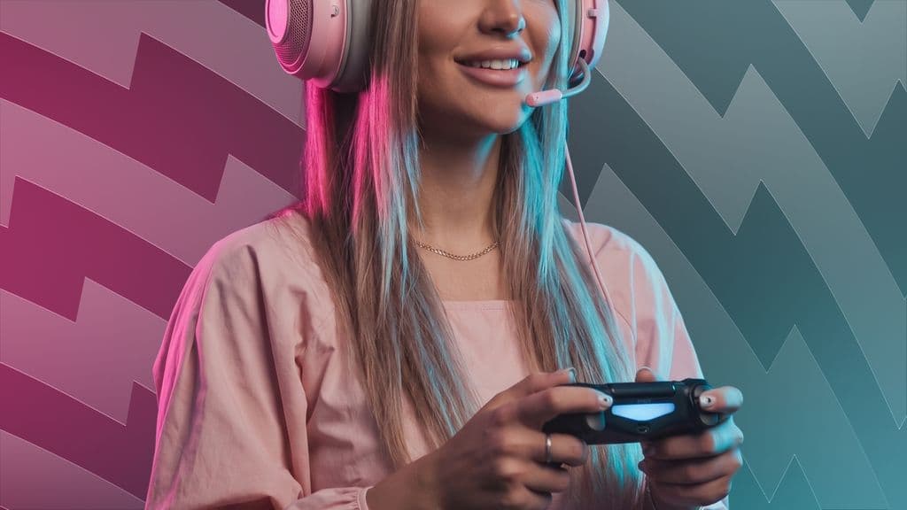 A woman in pink headphones holding a game controller, in front of WolkaStore's pink and teal zigzag pattern.